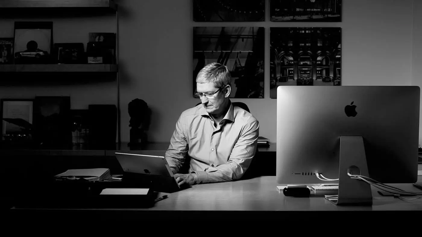 Tim Cook en una oficina escribiendo en un IPad con un Mac a la derecha